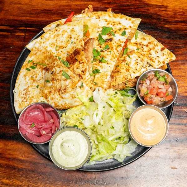 Chicken quesadillas with pico de gallo, pickled onions, shredded lettuce, and two sauces.